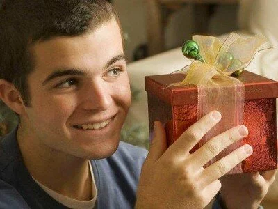парень держит в руках подарочную коробочку