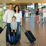 семья с чемоданами на колесах в ажропорту